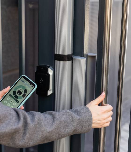 Smart home concept - close up of woman use mobile phone to open electronic lock.